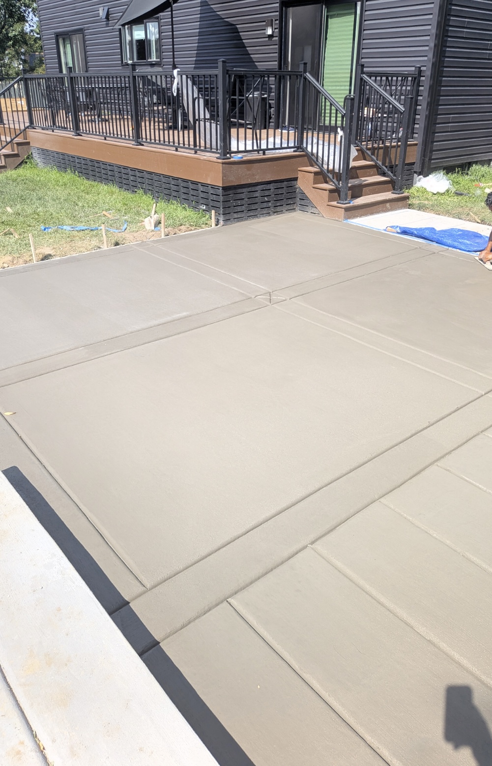 Freshly poured concrete patio slab behind a residential home