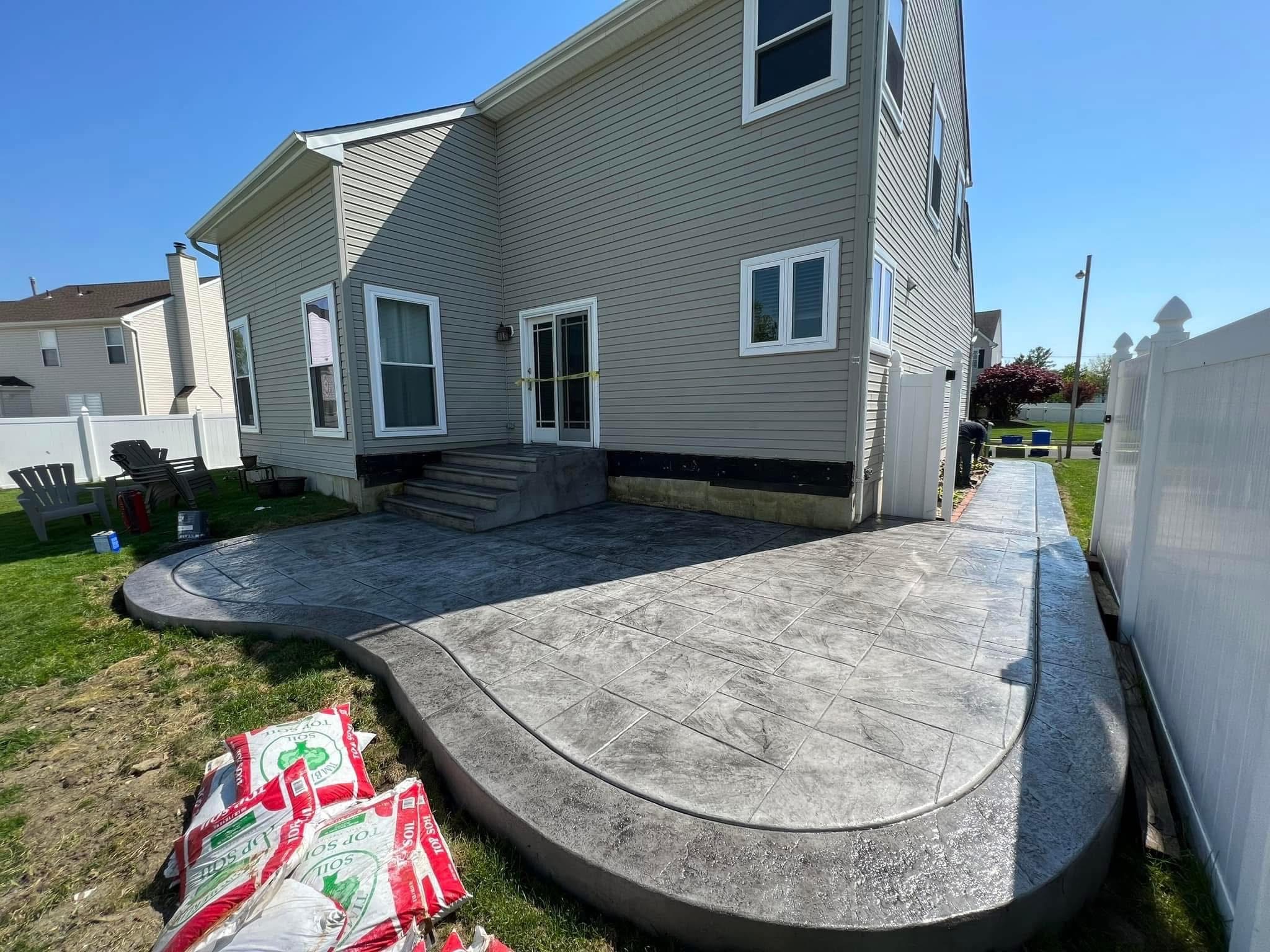Stamped concrete patio and walkway with a stone tile pattern
