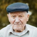 Elderly man wearing a flat cap, smiling gently, representing the trust and reliability of US Concrete Construction in serving South Jersey families.