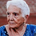 Elderly woman with white hair and a blue shirt, reflecting wisdom and experience, representing the trusted service of US Concrete Construction in South Jersey.