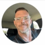 Man smiling in a car, representing the team at US Concrete Construction, South Jersey's trusted concrete experts.